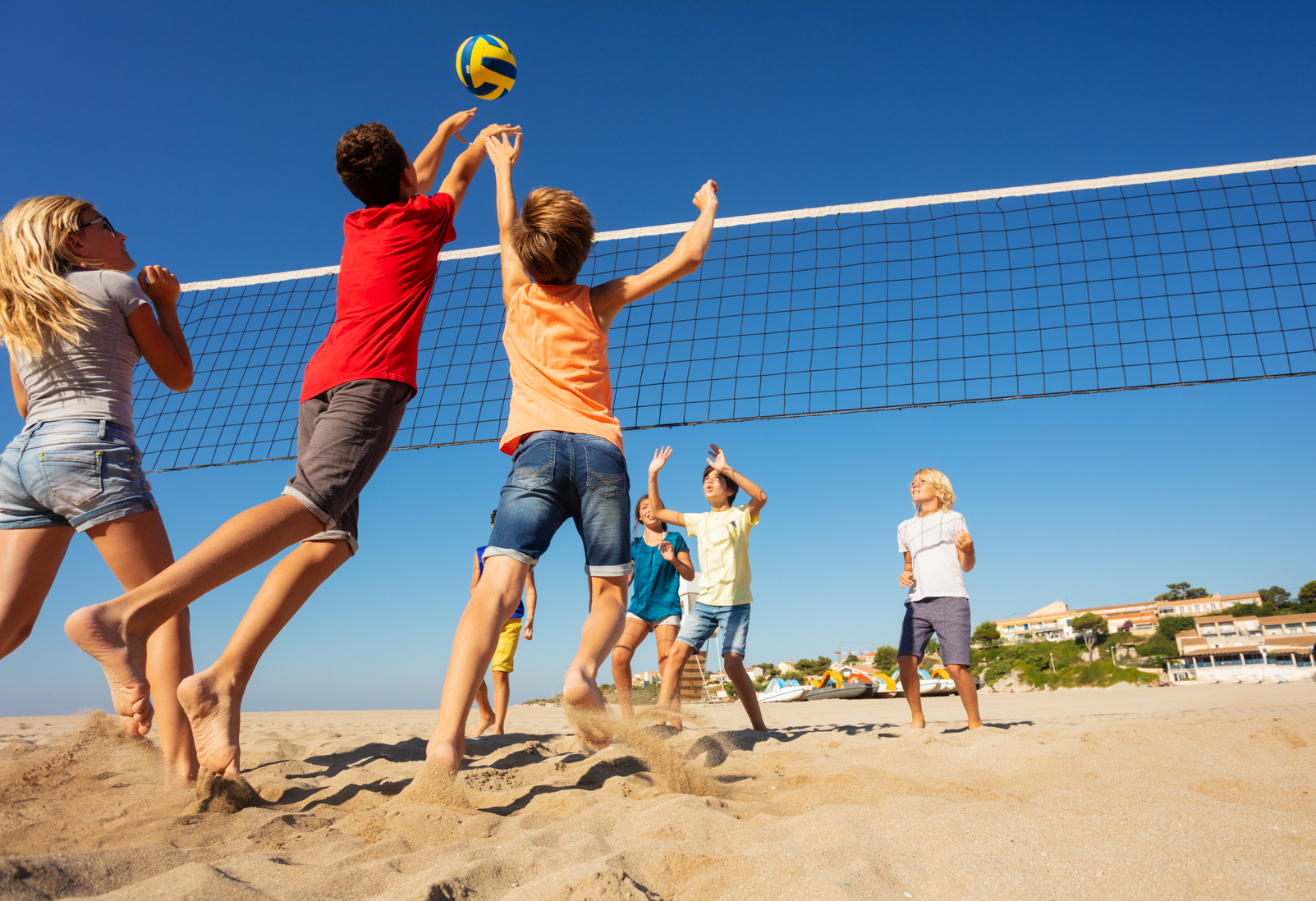 Beach Volleyball Players Jumping to Spike the Ball